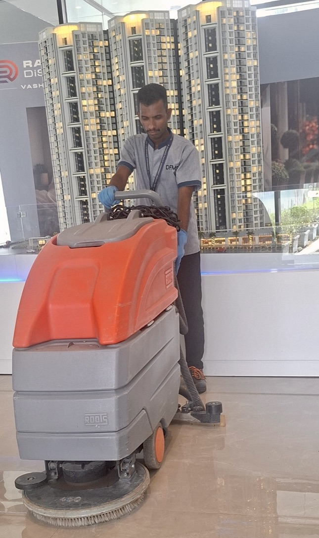 DFMS technician operating industrial floor scrubber at a commercial property